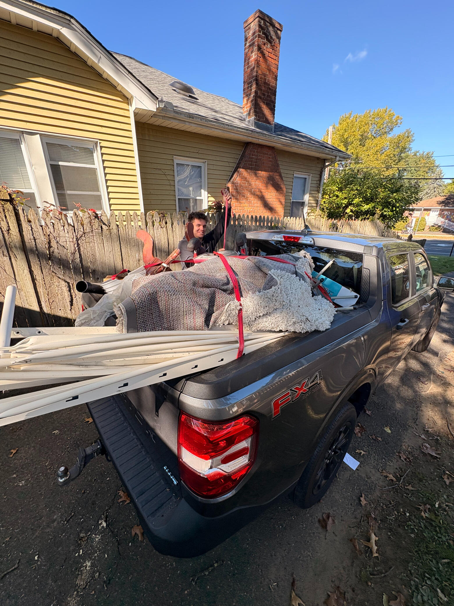 JunkBuddies crew loading a pickup with furniture and household items.